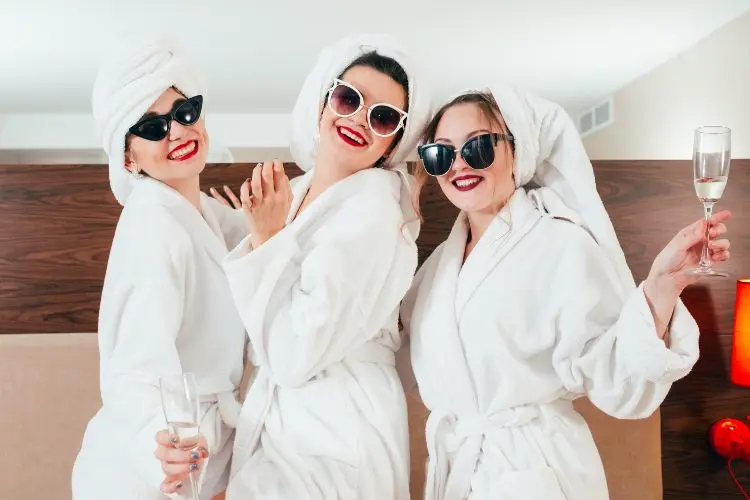 Des copines s'amusent en prenant des photos en peignoir avec des lunettes de soleil