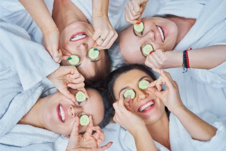 Des femmes prennent soins d'elles en mettant du concombre sur leurs yeux.