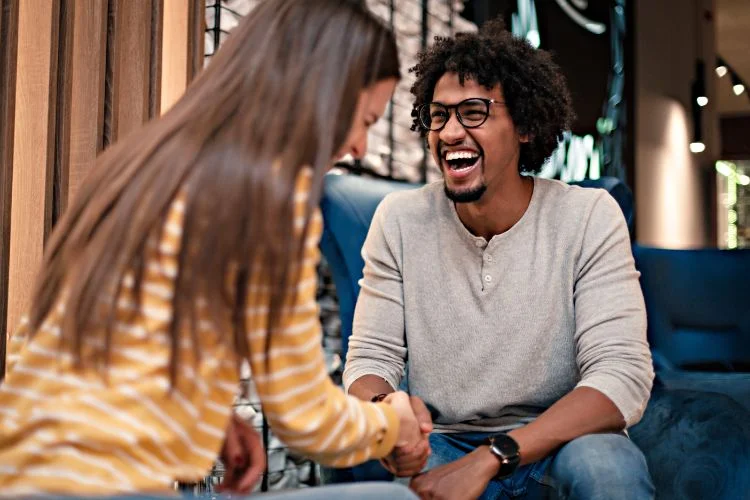 Un homme et une femme qui se rencontre et rigolent ensemble.