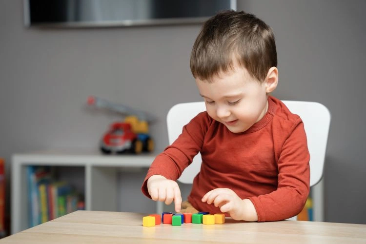 Petit garçon en train de jouer à un jeu éducatif