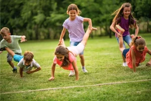 Enfants faisant une course de brouette dans une prairie
