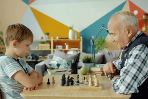 Grand-père jouant aux échecs avec son petit-fils