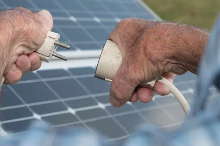Homme branchant des panneaux solaires plug & play