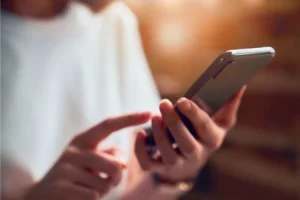 Personne ecrivant un texte sur son téléphone