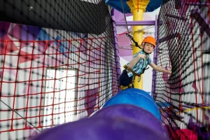 Enfant faisant de l'accrobranche en intérieur